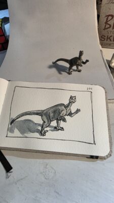 Toy velociraptor and an ink and watercolor wash